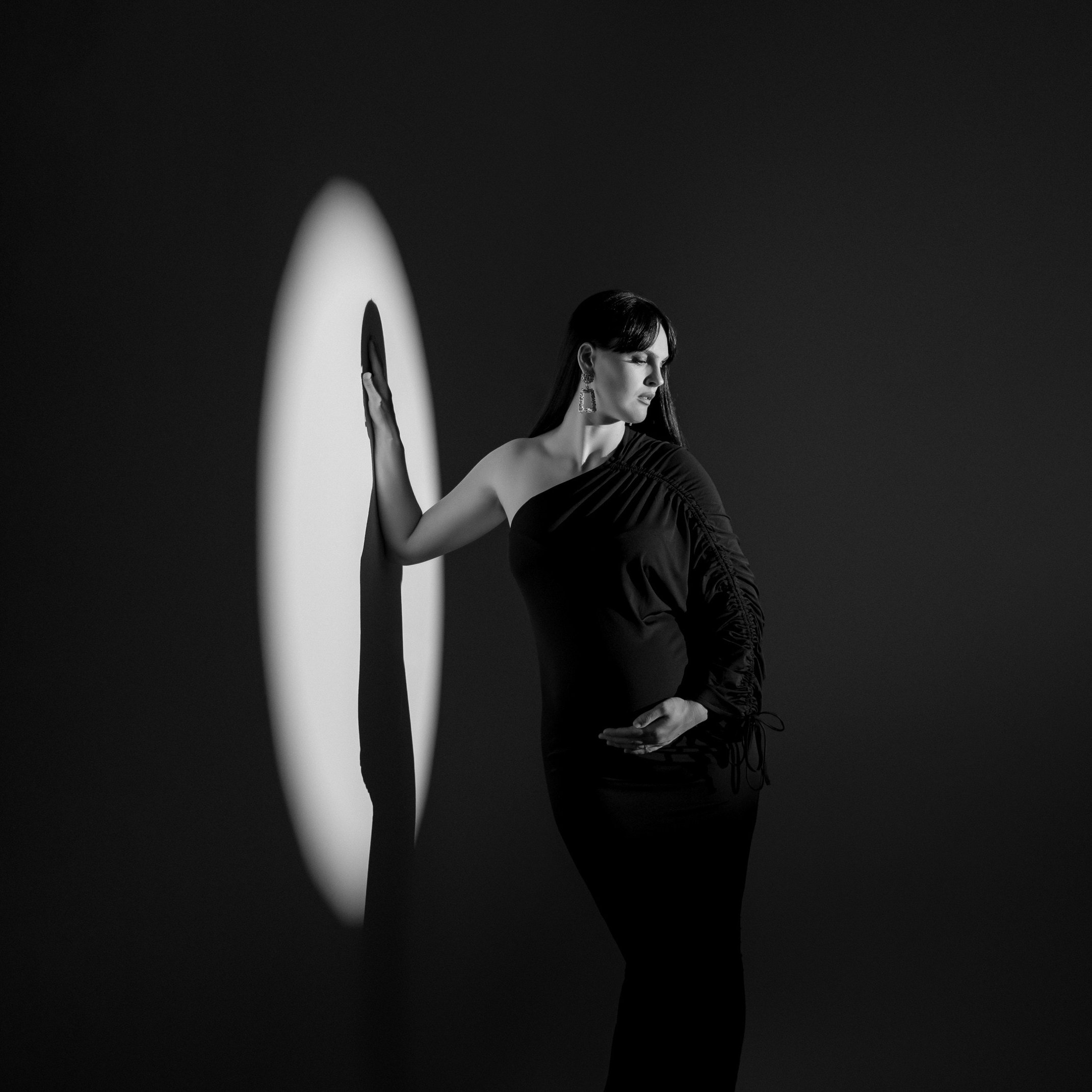 Stilno fotografiranje nosečnice v črni obleki v foto studiu