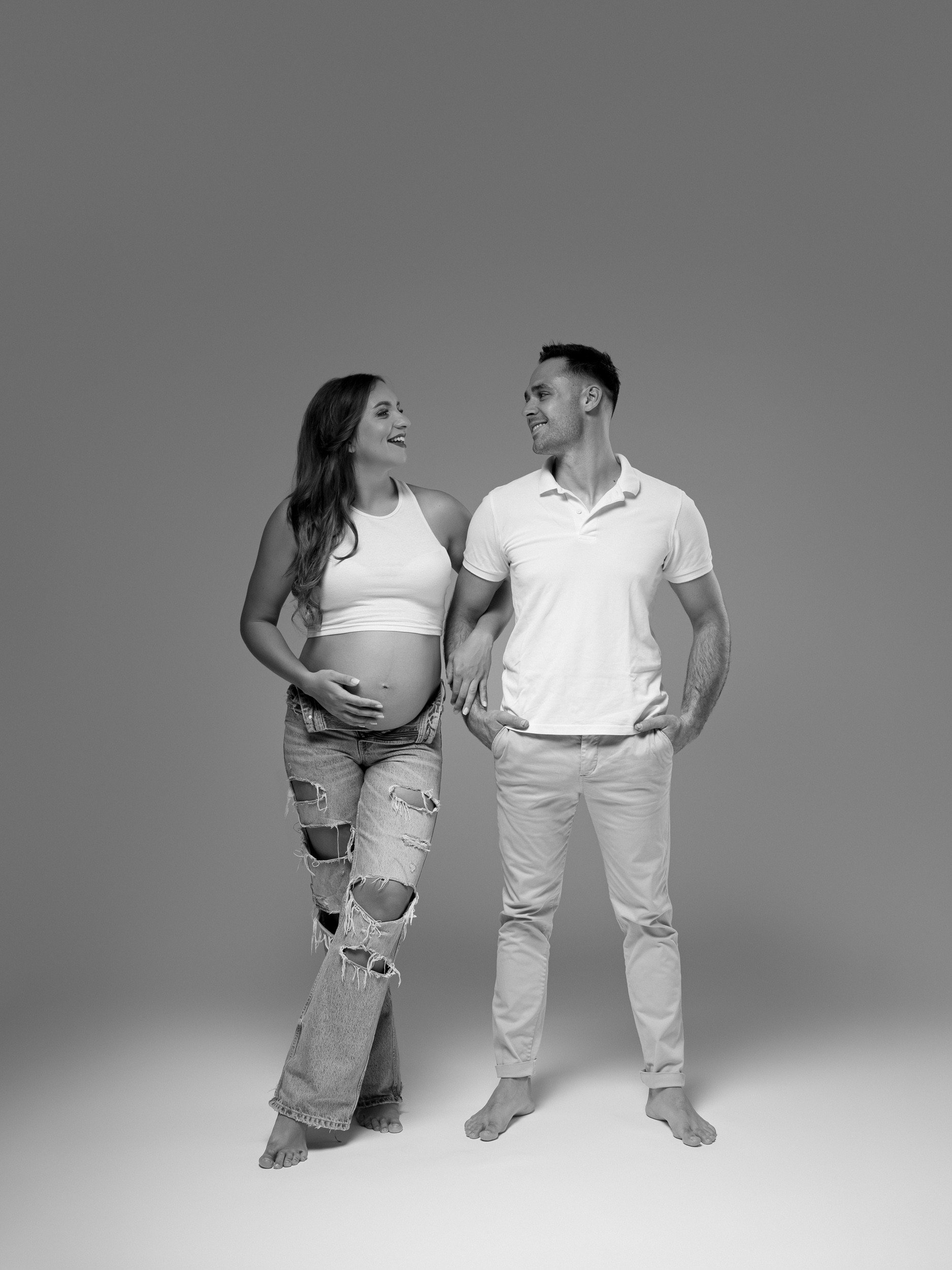 Fotografiranje nosečnice s partnerjem v studiu. Črno-bela fotografija