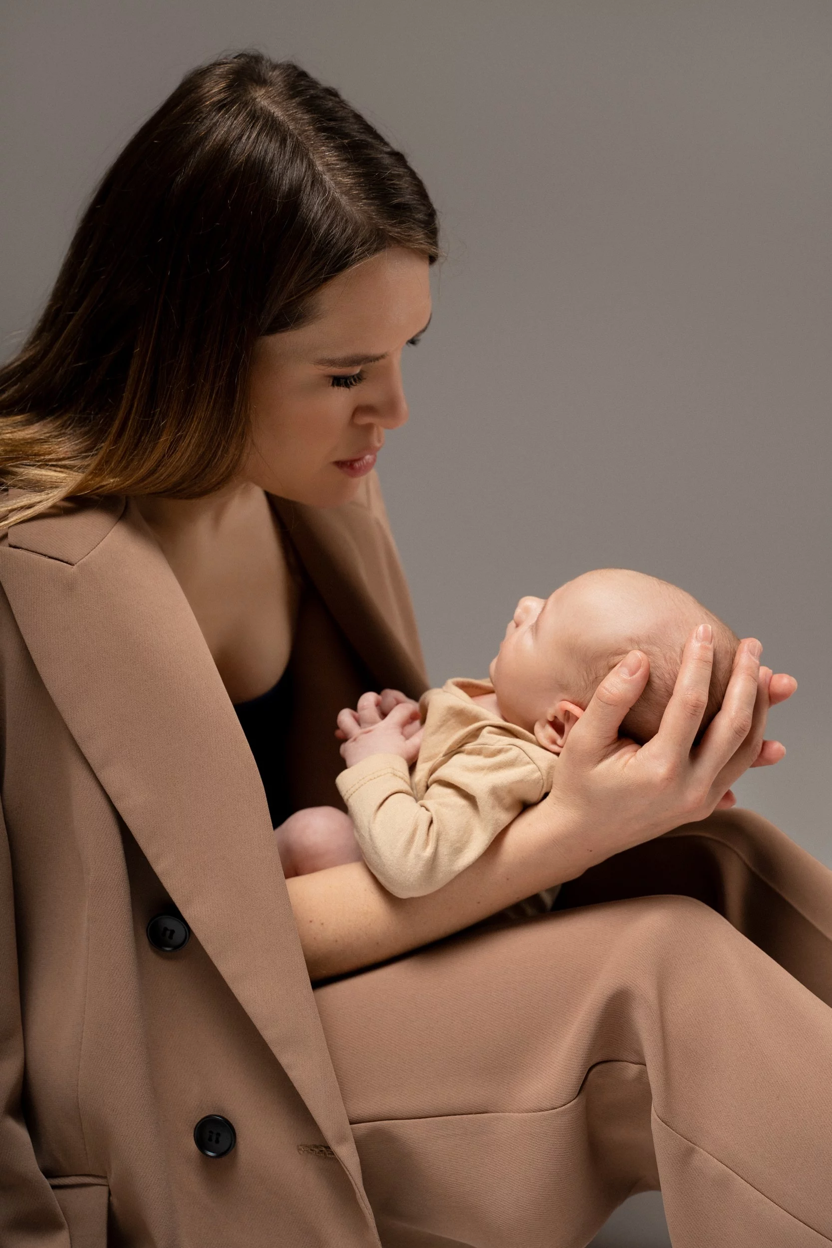 Fotografiranje novorojenčka v studiu: mama, ki drži novorojenčka