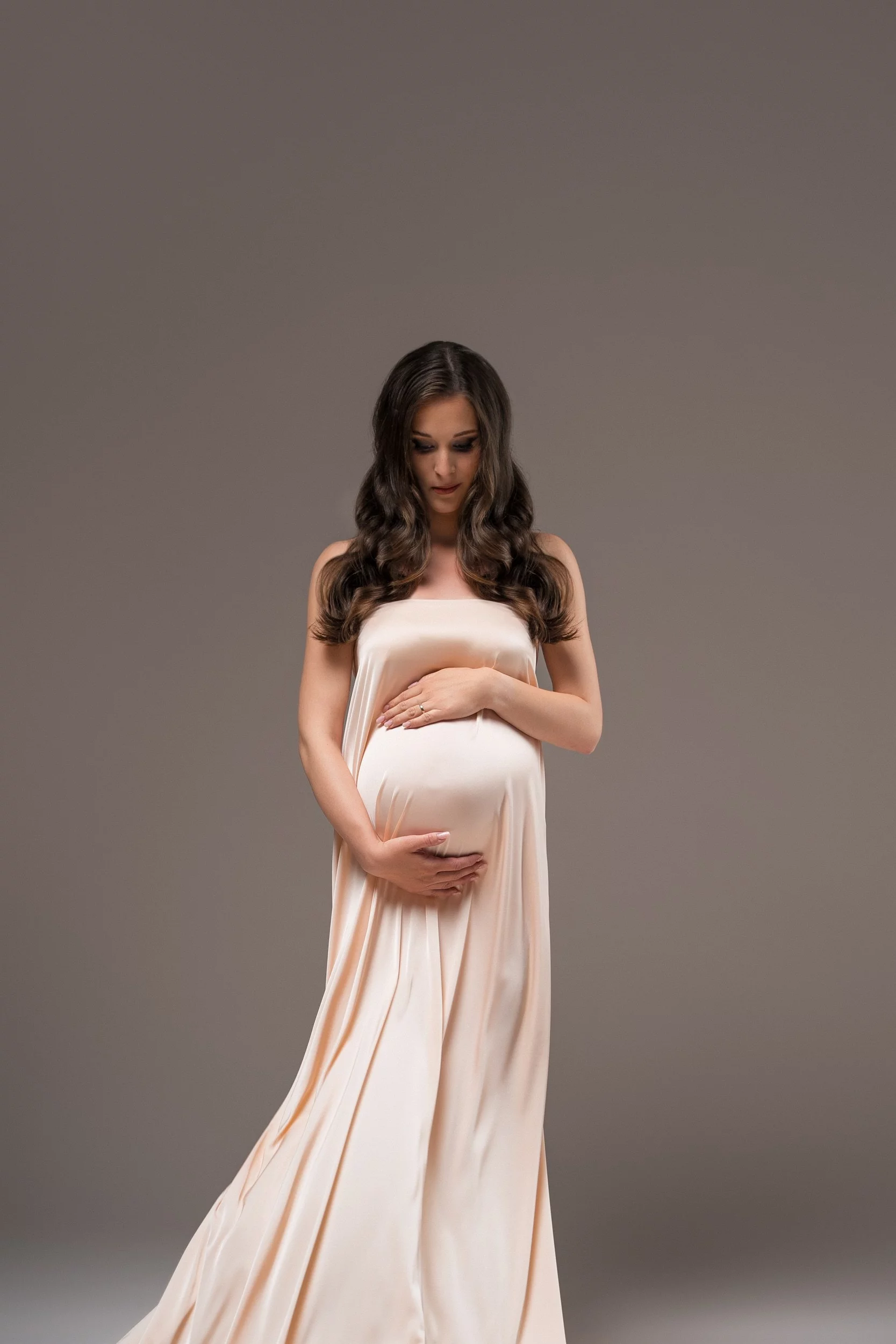 Stilno nosečniško fotografiranje v svetli obleki v foto studiu v Ljubljani